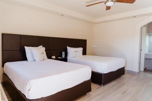 墨西卡利Hotel Siesta Real的卧室内两张并排的床