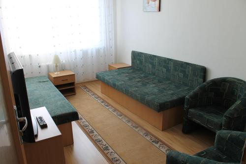 科希策ŠD Jedlíkova 5的客厅配有绿色沙发和椅子