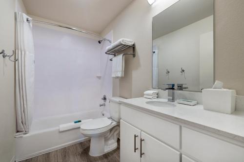 欧文Soka Suites Dallas - Las Colinas的白色的浴室设有卫生间和水槽。