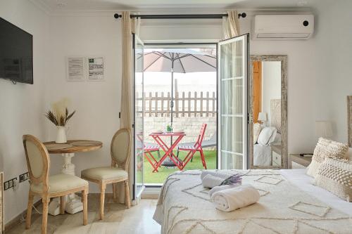 加的斯Studio Novena Little Apartments的一间卧室配有一张床铺和一张桌子,还有一个庭院