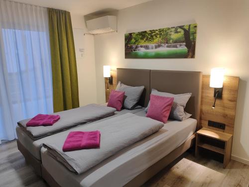 腓特烈港Hotel Gästehaus Stock Zimmer Bäumle的两张位于酒店客房的床,配有粉红色枕头