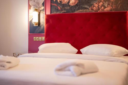 伊西翁L Suites The Writer's House的客房内的两张床和红色床头板