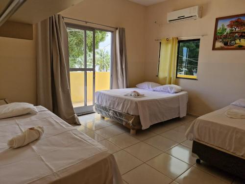 索雷HOTEL E RESTAURANTE ILHA BELA的酒店客房设有两张床和窗户。