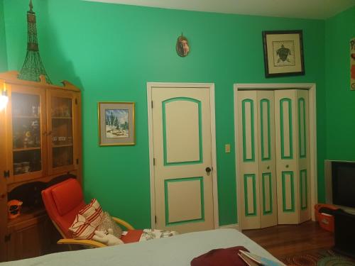 Harveys LakeHarvey's Lake/near Rickett's Glen的一间卧室设有绿色的墙壁、一扇门和一把椅子