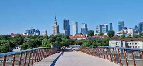 华沙Best Warsaw Panorama Bridge by Better Place的站在一座城市的桥上的女人