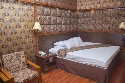 卡拉奇Faran Hotel的配有一张床和一把椅子的酒店客房