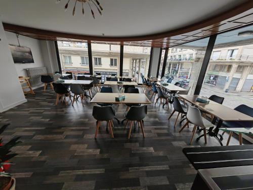 勒阿弗尔勒阿弗尔中心宜必思尚品酒店的一间设有桌椅的餐厅,位于带窗户的房间内