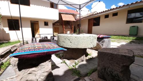 库斯科Munay Cusco的一张石桌和一些岩石,一座建筑