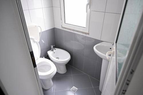 圣金Hotel 'DEL MAR' - Shengjin的白色的浴室设有卫生间和水槽。