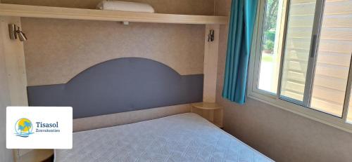 维亚雷焦Campsitechalet in Viareggio near sea incl airco的一间卧室配有一张带蓝色床头板的床和窗户