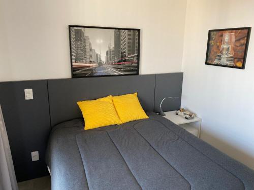 圣保罗Studio Quadra da Paulista的一间卧室配有一张带两个黄色枕头的床