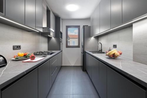 维斯尼安Apartment Larissa的厨房配有灰色橱柜和水果台