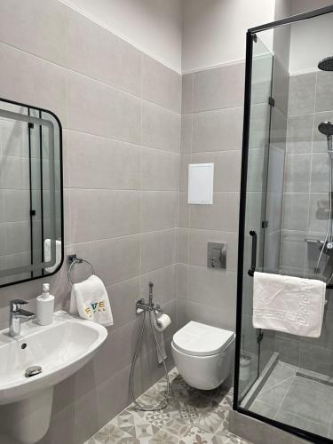 阿斯塔纳Five Hotel的浴室配有卫生间、盥洗盆和淋浴。