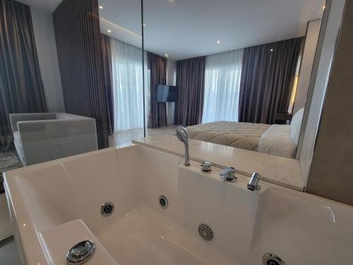 波格拉德茨Hotel Enkelana的带浴缸的浴室和1间带1张床的卧室