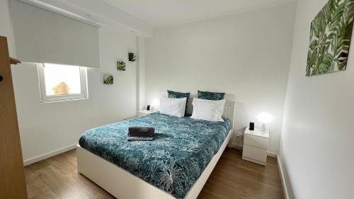蓬塔德尔加达Casa vereda Two, Ponta Delgada, S Miguel的白色卧室配有一张带蓝色毯子的床