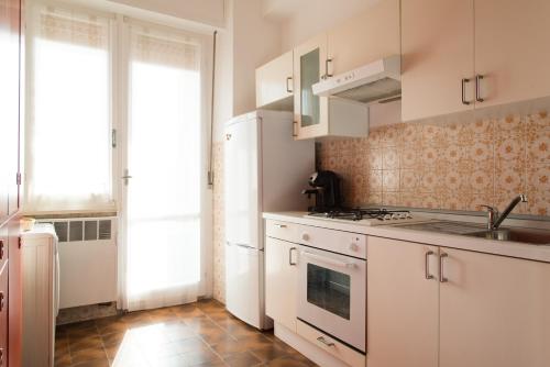 PosatoraLa Casa di Merion的厨房配有白色橱柜和水槽