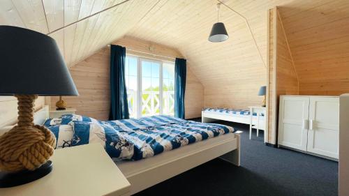 加茨比亚格拉Domki Faro的一间卧室设有一张床和一个窗口