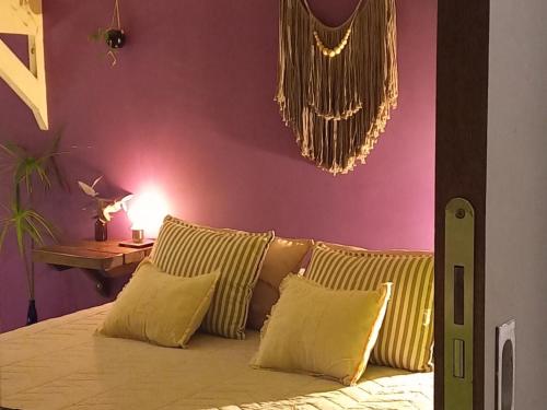 马德普拉塔Casa Bendita Pacha的一间卧室配有一张带黄色枕头的床和紫色墙壁
