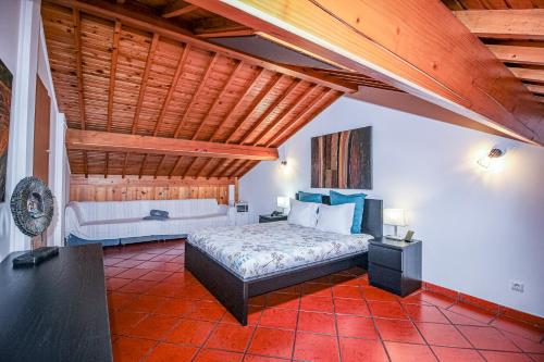 蓬塔德尔加达Casa Vereda, Ponta Delgada, S. Miguel的一间卧室设有一张床和木制天花板