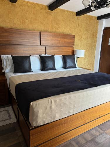 瓜达拉哈拉Hotel Boutique La Mansión Guadalajara的一间卧室配有一张大床和木制床头板