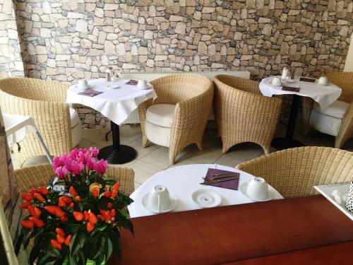 科隆阿里亚纳酒店的一间带两把桌子和椅子的餐厅,并种植了鲜花