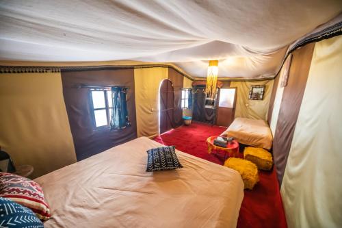 El GoueraAladdin Desert Camp的一间帐篷内带两张床的卧室