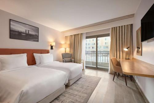 开罗Radisson Residences Cairo Heliopolis的酒店客房配有两张床和一张书桌