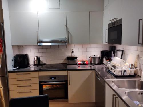 南泰利耶Jahminatu`s Apartment的厨房配有白色橱柜和炉灶烤箱。