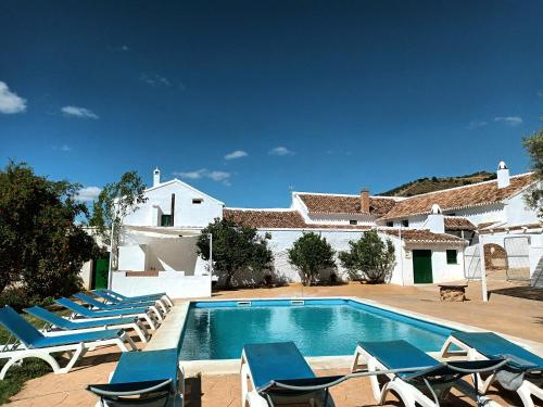 阿尔奇多纳科尔蒂霍安泽米格雅度假屋的一个带躺椅的游泳池以及一座房子