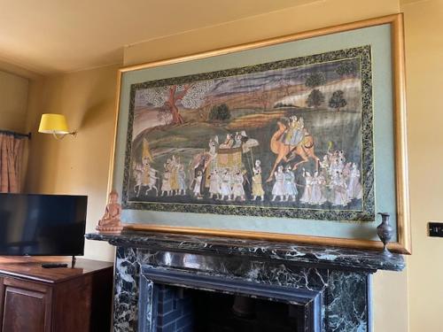 威尔斯浦Llanerchydol Hall Suites的客厅壁炉上方的画作