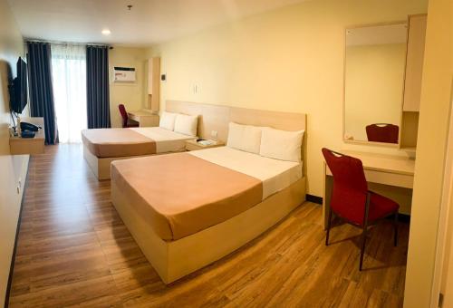 碧瑶Olive Town Center and Hotel的酒店客房,设有两张床和一张红色椅子