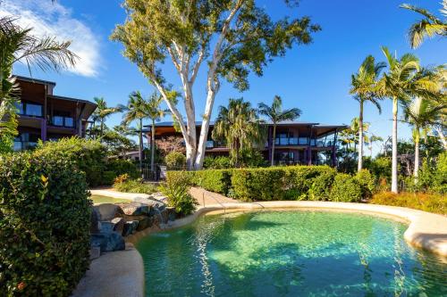 汉密尔顿岛昂克拉吉尔酒店的棕榈树度假村前的游泳池