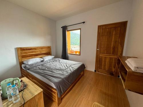 布罗莫Homestay Lereng Bromo的一间卧室配有一张床、一张桌子和一个窗户。
