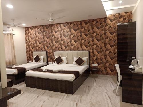 蓬蒂切里Veeras Residency的一间卧室设有两张床和木墙