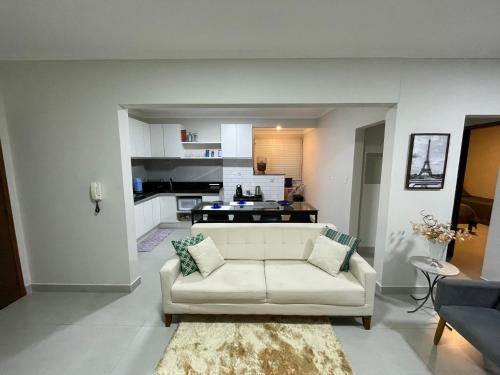 圣洛伦索Apartamento no centro de São Lourenço 100% reformado的一间带白色沙发的客厅和一间厨房