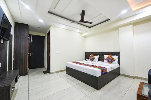 新德里FabHotel Dwarka Residency的一间卧室配有一张床和一台电视