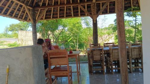 EkasMelody Surf Camp - Ekas Lombok的坐在餐厅桌子上的一对夫妇