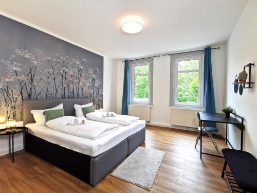 伊尔梅瑙BohnApartments - Stadtblick Zechenhaus - Balkon - gratis Parkplatz - WLAN - sehr ruhig - barrierearm的一间卧室设有一张大床和两个窗户。