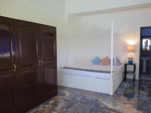 莫阿尔博阿The Wild Orchid Resort - Moalboal的一间卧室配有一张玻璃墙床
