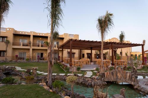 锡瓦Siwa Sunrise Hotel的一座拥有棕榈树的大型建筑的度假村