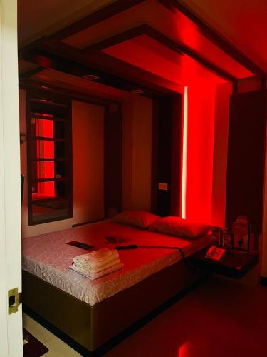 安吉利斯邦板牙大有崇光酒店的一间卧室配有红色灯床