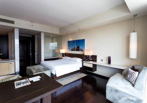 新德里The EL DE Belwood Hotel By Delhi Airport的卧室配有一张床和一张桌子及椅子