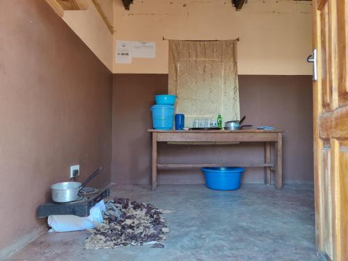 利文斯顿Simoonga Thandizani School的一间设有桌子和蓝色锅碗瓢盆的房间