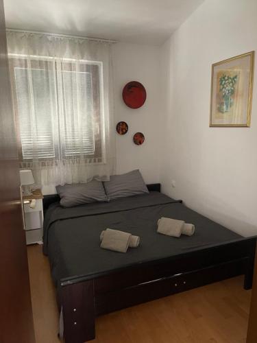 普纳特Apartments Natasa的一间卧室配有一张床,上面有两条毛巾