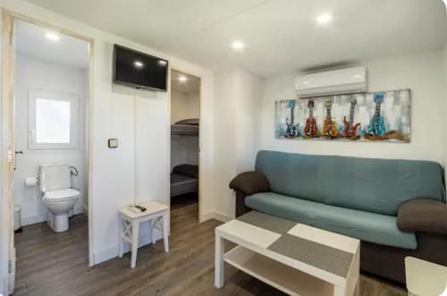 博罗尼亚Apartamento en Bolonia的一间带蓝色沙发的客厅和一间浴室