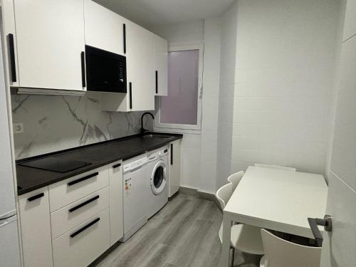 洛格罗尼奥Céntrico apartamento reformado de dos habitaciones的厨房配有白色橱柜、洗衣机和烘干机