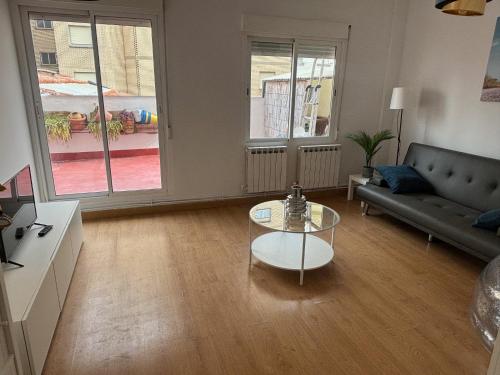 洛格罗尼奥Céntrico apartamento reformado de dos habitaciones的带沙发和玻璃桌的客厅