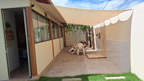 CorrentinaStudio Aconchego Correntina的房屋旁带遮阳篷的庭院