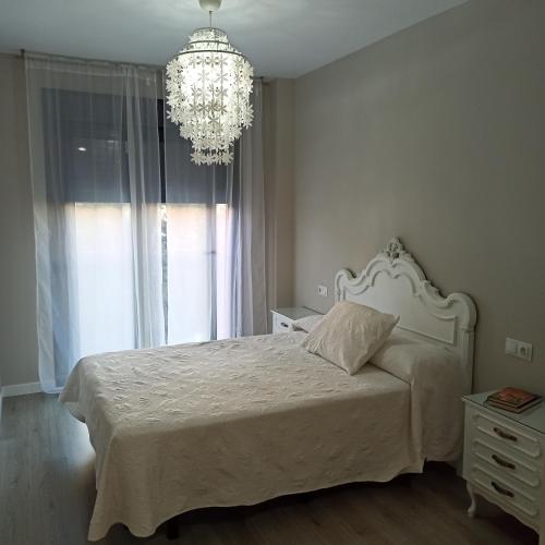 贝纳哈拉菲Apartamento MyR的卧室配有白色的床和吊灯。