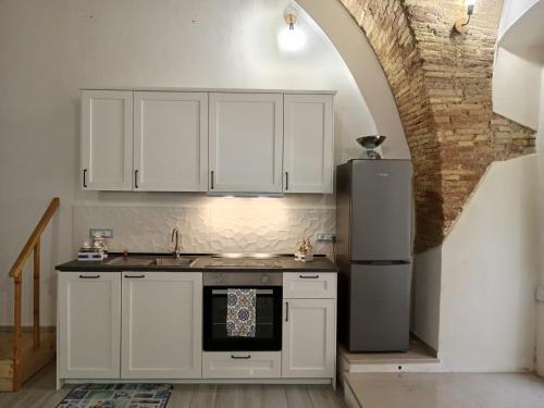 泰尔莫利GiuattyHomeHoliday Termoli的厨房配有白色橱柜和冰箱。